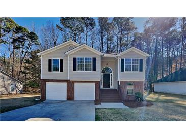 Charming two-story home features a two-car garage and a beautifully landscaped front yard at 7021 Hillcrest Chase Ln, Austell, GA 30168