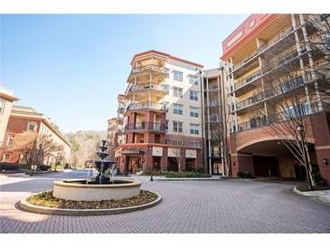 Stately condo exterior featuring multiple balconies, brick accents, and a tranquil fountain at 200 River Vista Dr # 736, Atlanta, GA 30339