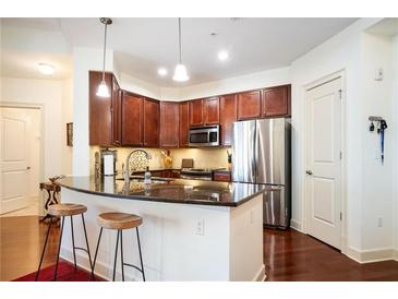 Modern kitchen with stainless steel appliances, breakfast bar, and dark wood cabinets at 200 River Vista Dr # 736, Atlanta, GA 30339
