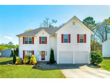 Charming two-story home with white siding, red shutters, and well-manicured lawn at 6675 Princeton Park Ct, Lithonia, GA 30058