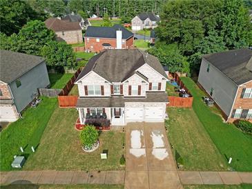 Inviting two-story home with a well-manicured front yard and a two-car garage, perfect for Gathering living at 9348 Lantana Trl, Jonesboro, GA 30238