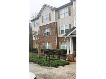 Inviting multi-story townhome features brick accents, neutral siding, and green shutters at 2302 Waldrop Pl, Decatur, GA 30034