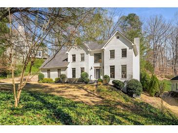 Charming white brick home with a well-manicured front yard and mature trees, offering great curb appeal at 2115 Azalea Dr, Roswell, GA 30075