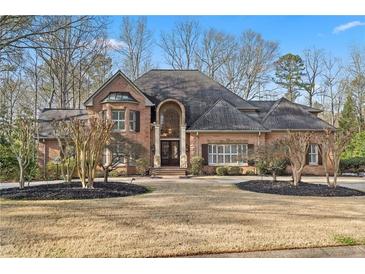Stately brick home featuring a well-manicured lawn and a symmetrical design at 9185 Old Southwick Pass, Johns Creek, GA 30022
