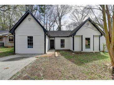 Charming one story home with white siding, black trim and a concrete driveway at 5393 Ridge Forest Dr, Stone Mountain, GA 30083