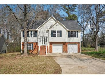 Charming two-story home features a two-car garage, inviting entrance and beautiful front yard at 1542 Bogota Way, Jonesboro, GA 30236