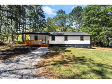 Charming renovated ranch-style home with a cozy front porch and well-maintained front yard surrounded by mature trees at 4739 Cook Sw Rd, Stockbridge, GA 30281