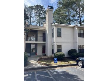 Well-maintained two-story condo featuring neutral stucco exterior and ample parking at 2611 Huntingdon Chase, Atlanta, GA 30350