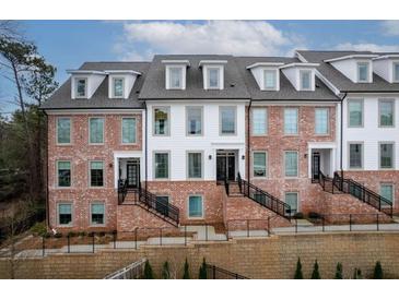 Charming townhomes boast a brick facade, white siding, and striking black accents, inviting curb appeal at 531 Burton Dr, Alpharetta, GA 30009