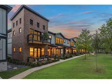 Charming brick townhomes with landscaped yards, patios and balconies against a beautiful dusk sky at 937 Willingham Dr # 7, Hapeville, GA 30354