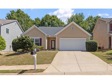 Charming single-story home featuring manicured lawn, neutral siding, and an attached two-car garage at 310 Tuggle Court, Woodstock, GA 30188
