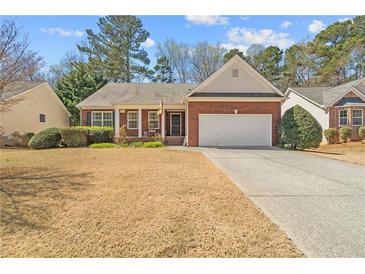 Charming single-story brick home featuring an attached garage and a well-manicured lawn in a desirable neighborhood at 564 Grand Ashbury Ln, Sugar Hill, GA 30518