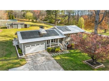 Charming home with solar panels, a metal roof, a garage, landscaping, and a large yard at 5320 Karr Rd, Cumming, GA 30040