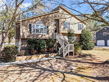 Charming two-story home featuring a welcoming entryway staircase, complemented by mature landscaping and a detached garage at 610 Amberwood Pl, Euharlee, GA 30145