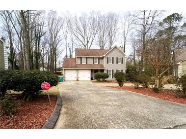 Charming two-story home with a long driveway and a well maintained, landscaped front yard at 5166 Ridge Tarn, Acworth, GA 30102