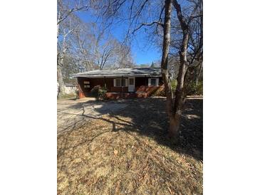 Cozy brick home with a simple front porch, nestled among mature trees in a quiet neighborhood at 1033 Mclendon Dr, Decatur, GA 30033