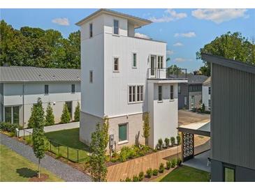 Striking modern home featuring a unique tower design, complemented by professional landscaping and mature trees at 380 2Nd St, Fayetteville, GA 30214