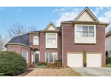 Lovely two story brick home featuring an attached two car garage and manicured lawn at 3770 Summit Gate Dr, Suwanee, GA 30024