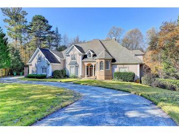 Beautiful two-story home with a circular driveway and well-manicured lawn at 3871 River Mansion Dr, Peachtree Corners, GA 30096