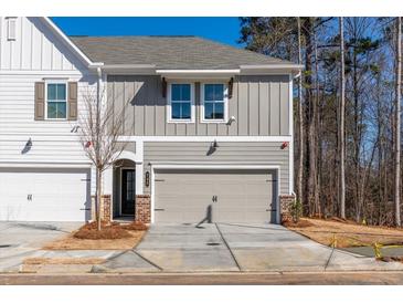 Charming townhome featuring neutral colors, a two car garage, and well-manicured landscaping at 163 Bluffington Way, Marietta, GA 30066