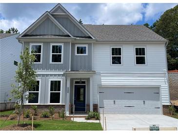 Charming two-story home featuring a mix of gray and white siding, a two-car garage, and a well-manicured front yard at 4300 Easter Lily Ave Lot 11, Buford, GA 30519