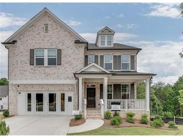 Charming two-story brick home with a covered front porch and attached two-car garage at 674 Allier Ter, Cumming, GA 30041