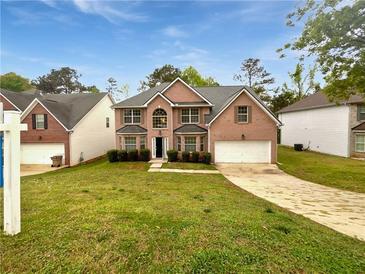 Charming two-story brick home featuring a well-manicured lawn and attached two-car garage at 1882 Byrom Pkwy, Jonesboro, GA 30236