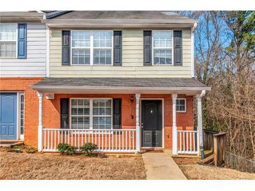 Charming two-story townhome featuring a brick facade, covered front porch and a well-manicured lawn at 2025 Shawn Wayne Se Cir, Atlanta, GA 30316