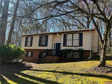 Split-level home featuring a brick foundation, front porch, and an inviting facade in a wooded neighborhood at 6625 Paula Ct, Lithonia, GA 30038
