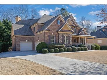 Beautiful brick home with a three car garage and manicured lawn in a well-maintained community at 1420 Orange Shoals Dr, Canton, GA 30115