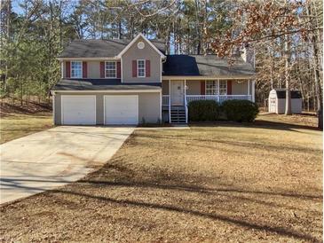 Charming two-story home featuring a well-maintained front yard, two-car garage and covered front porch at 230 Nina Cir, Locust Grove, GA 30248