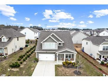 Charming two-story home featuring a well-maintained front yard with healthy green landscaping and a two-car garage at 2466 Bear Mountain St, Lithonia, GA 30058