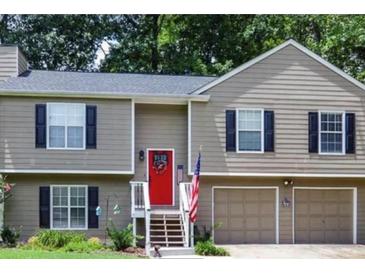 Charming home with a red door, black shutters, and an American flag at 3570 Mill Creek Drive Sw Dr, Smyrna, GA 30082
