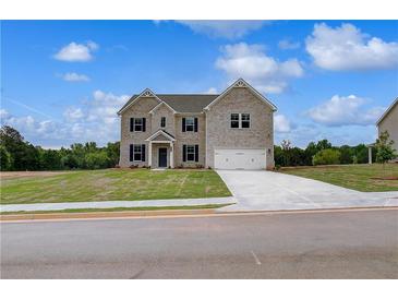 Charming two-story home featuring a well-manicured lawn and a spacious two-car garage at 111 Felicity Pike, Locust Grove, GA 30248