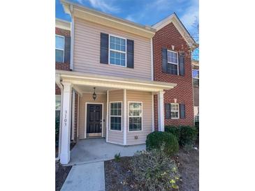 Charming townhouse with a covered front porch, beige siding, and brick accents offers a welcoming curb appeal at 2555 Flat Shoals Rd # 3103, Atlanta, GA 30349