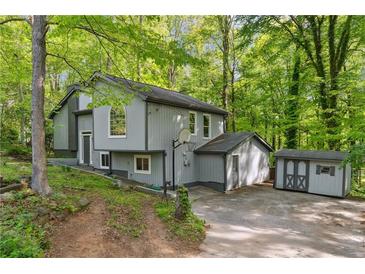 Two-story home with gray siding and a well-maintained yard surrounded by mature trees at 1291 Marcelle Heights Pl, Norcross, GA 30093