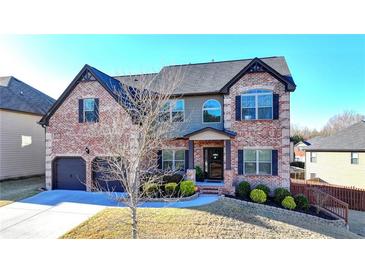 Charming two-story brick home featuring a two-car garage, manicured landscaping, and a welcoming entrance at 2640 Paddock Point Pl, Dacula, GA 30019