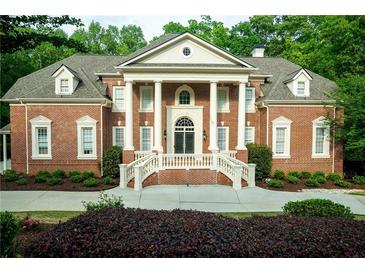 Stately brick home with grand entrance featuring white columns and manicured landscaping at 350 Newcastle Dr, Alpharetta, GA 30009
