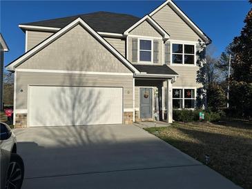 Charming two-story home with a well-maintained lawn, gray siding, and a two-car garage at 101 Waters Edge Pkwy, Temple, GA 30179