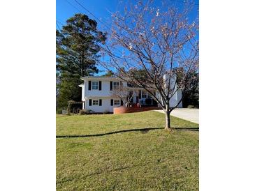 Well maintained two-story home with a manicured lawn and mature trees providing shade and curb appeal at 1316 Milstead Ave, Conyers, GA 30012