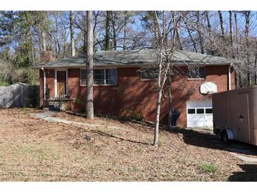 Charming brick home with a single-car garage, front entrance, and landscaped front yard at 754 Walnut Sw Cir, Marietta, GA 30060