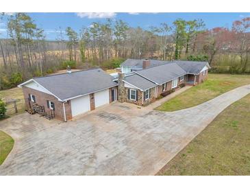 Expansive brick home featuring a two-car garage, stone accents, and a long driveway on a large lot at 2716 Georgia 16, Carrollton, GA 30116