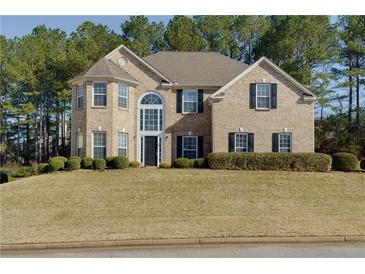 Charming two-story brick home with manicured lawn and mature trees at 1368 Fall River Dr, Conyers, GA 30013