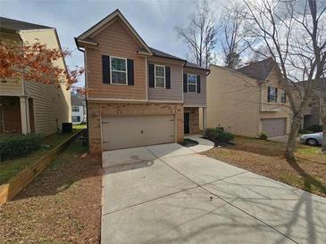 Two-story home featuring a front-entry garage and a long driveway leading up to the entrance of the house at 203 August West Way, Lawrenceville, GA 30046