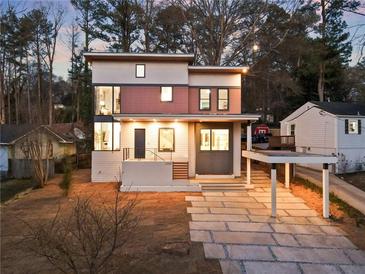 Modern two-story home featuring clean lines, a carport, and a stylish stone pathway to the front door at 1045 Shepherds Ne Ln, Atlanta, GA 30324