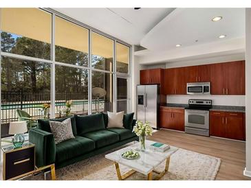 Bright living room featuring floor-to-ceiling windows and an open concept kitchen with stainless steel appliances at 3400 Malone Dr # 110, Atlanta, GA 30341
