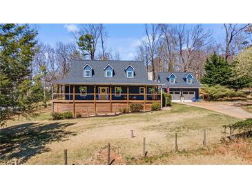 Charming two-story home with a welcoming front porch and well-maintained landscaping and matching detached garage at 6510 Akins Way, Cumming, GA 30041