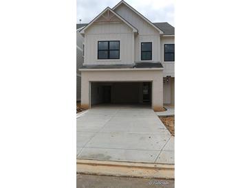 Two-story townhome features white painted brick and board and batten siding, plus a two-car garage at 1063 Crest Mill Dr, Marietta, GA 30008