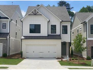 Charming two-story home features a white brick and siding, black trim windows, and a two-car garage at 1063 Crest Mill Dr, Marietta, GA 30008