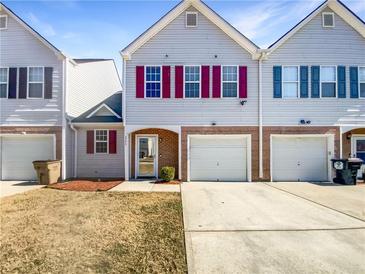 Charming two-story townhome with attached garage and well-maintained front lawn on a sunny day at 3756 Brookwood Blvd, Rex, GA 30273